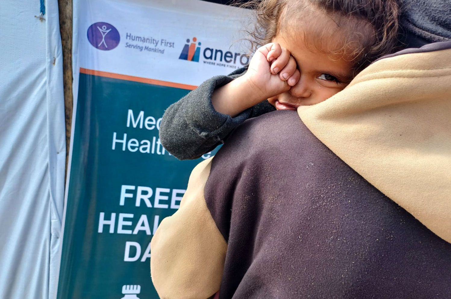 DR Gaza Anera Health Day 20240220 sleepy child in front of sign