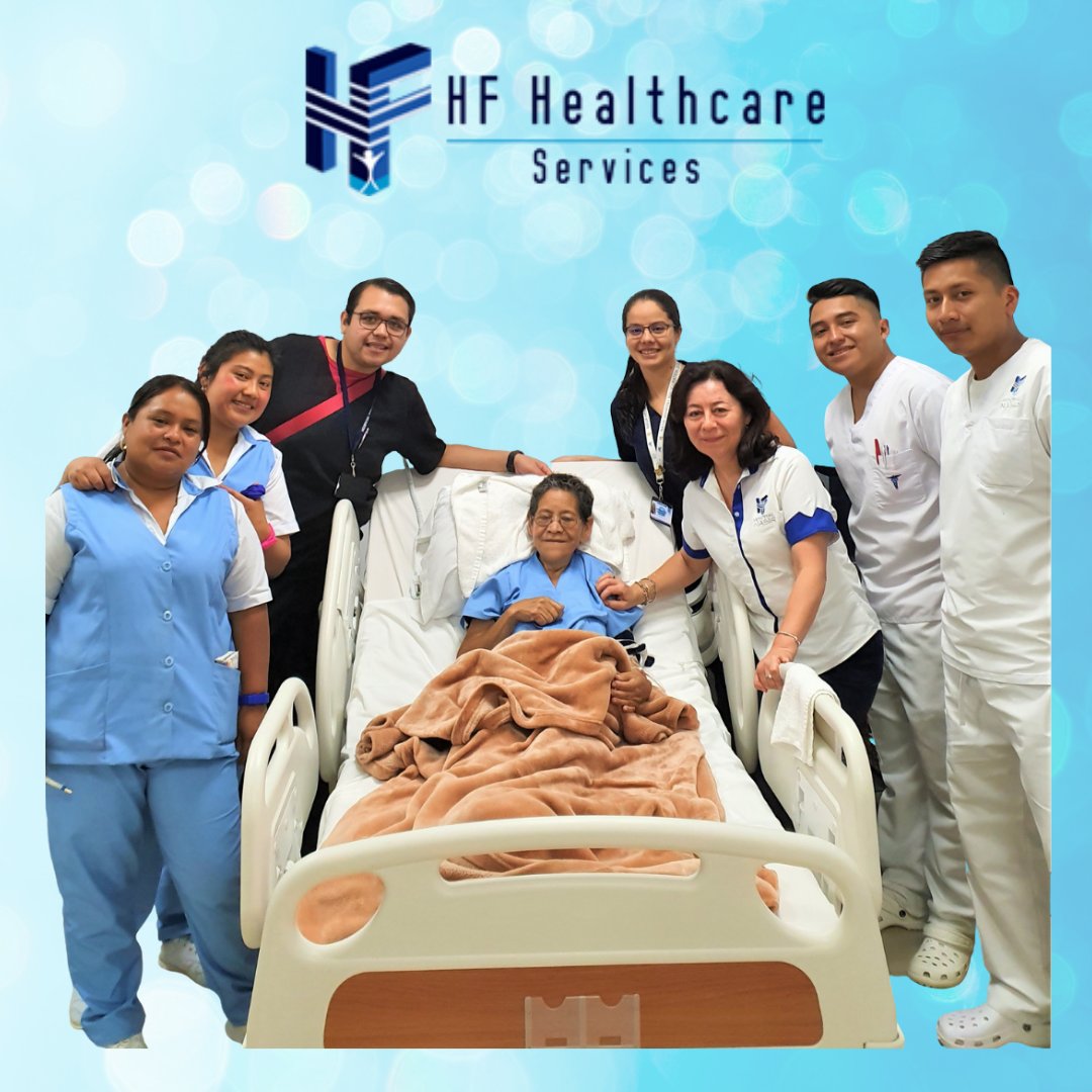 Men and women wearing medical scrubs stand around a hospital bed where an elderly woman is laying under a blanket. The background is computer generated blue with the logo of HF Healthcare Services at the top