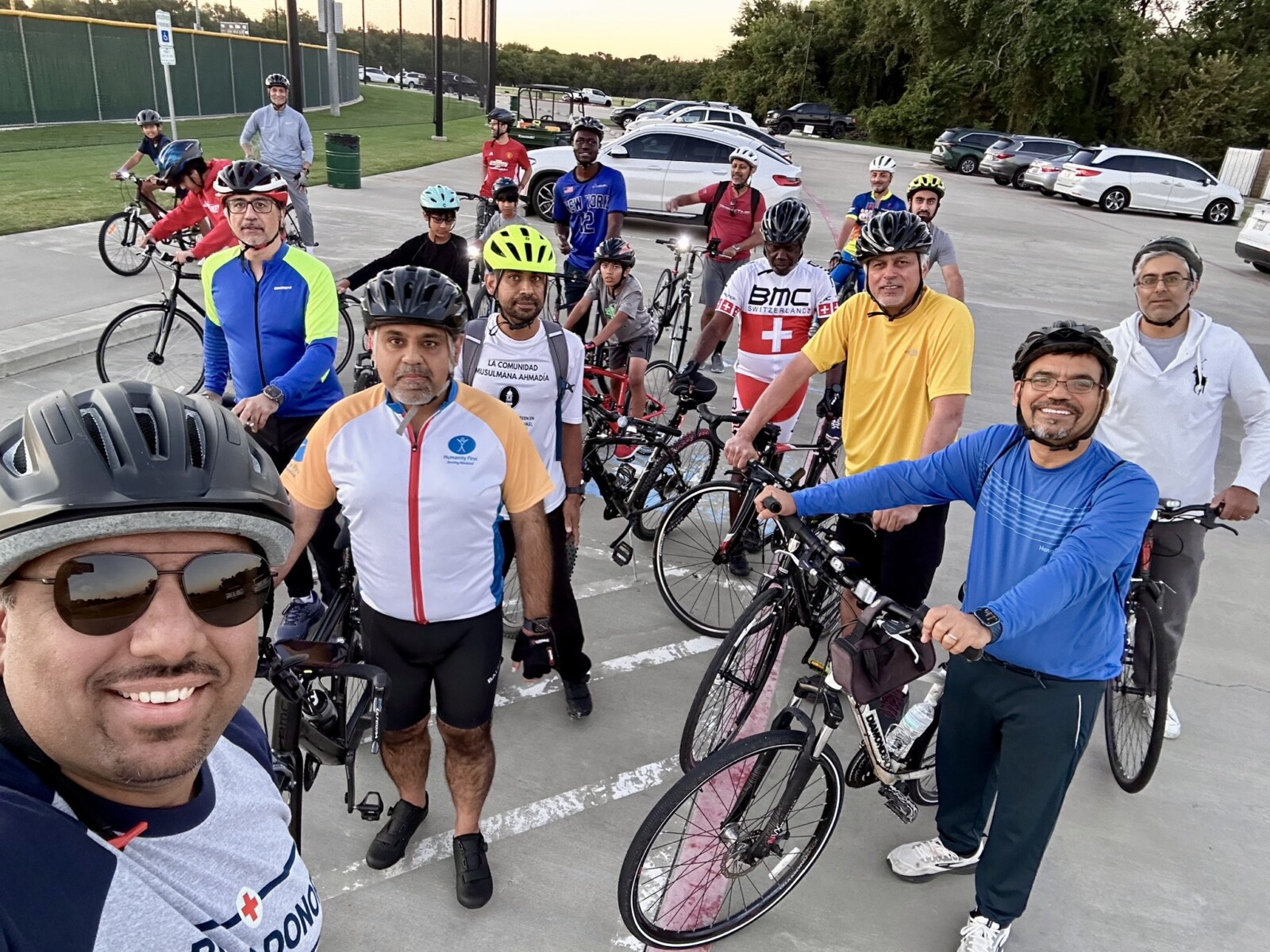 A dozen men taking a selfie with their bicycles