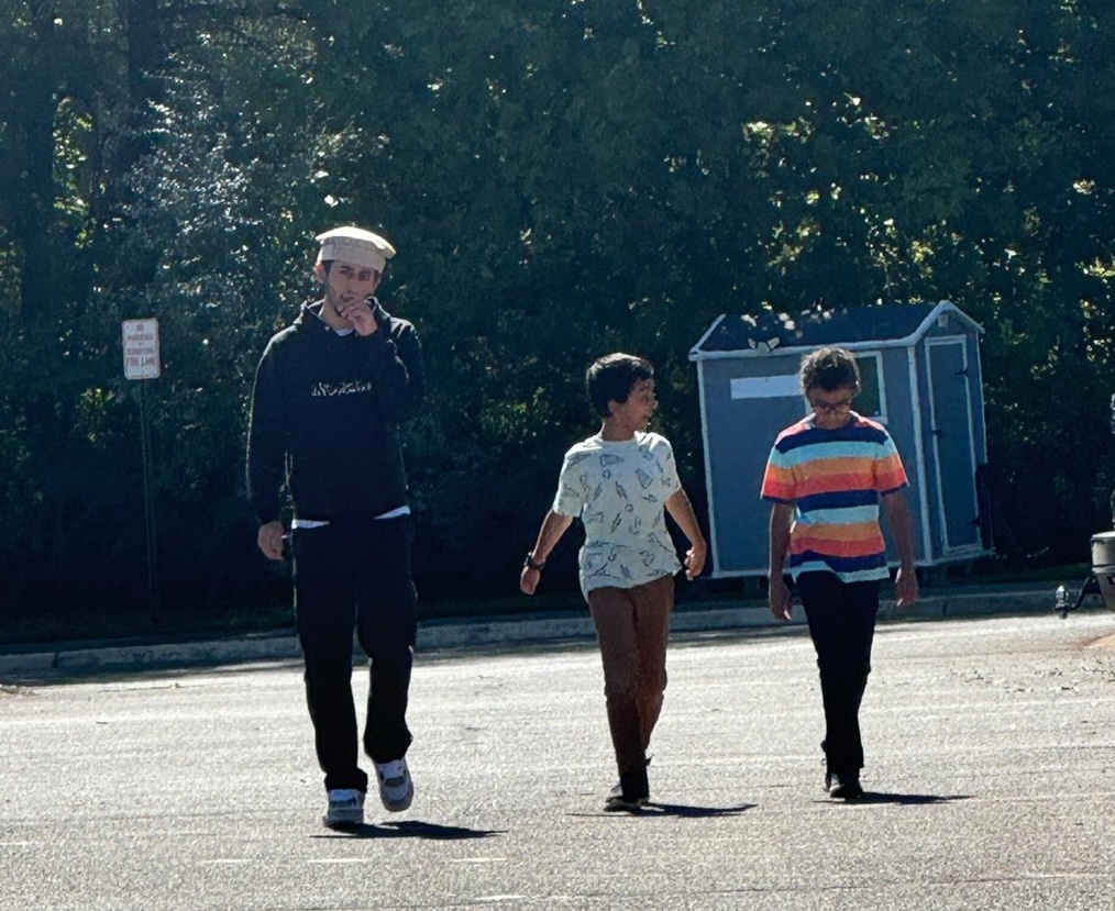 A man and two boys walk side by side