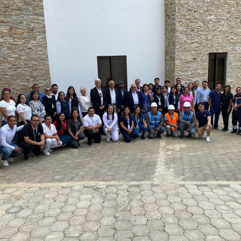 A large group of people pose in front of a new building.