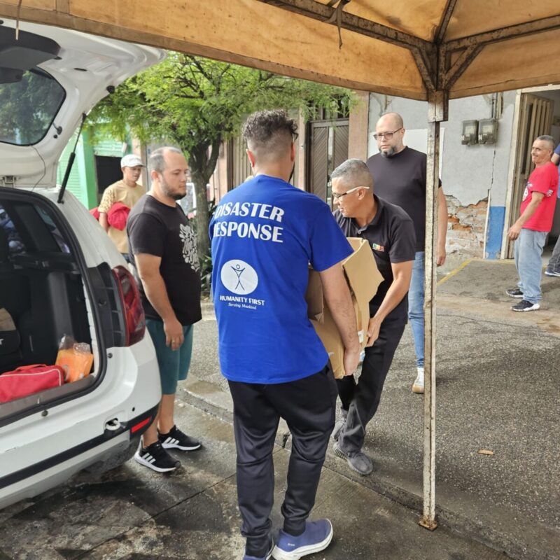 A Humanity First volunteer helps unload boxes from a car in Pereira, Colombia.